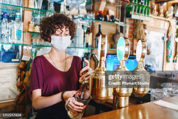 masked bartender filling beer - restaurant workers mask stock pictures, royalty-free photos & images