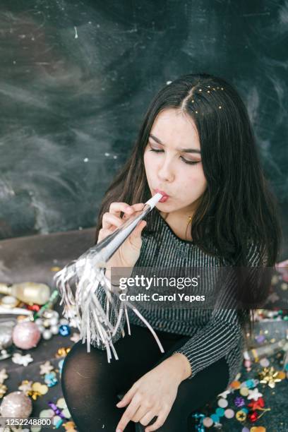 party young woman using party horn blower - party blower stock-fotos und bilder