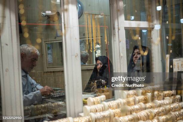 Two veiled Iranian women shop at a gold and jewelry shop at the historical traditional bazaar in the city of Ardabil in Ardabil province, 617 km...