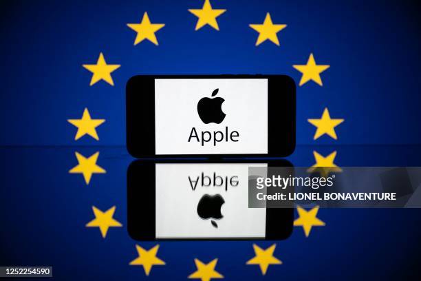 This picture taken on April 27, 2023 in Toulouse, southwestern France, shows a screen displaying the Apple logo and the European flag. - European...
