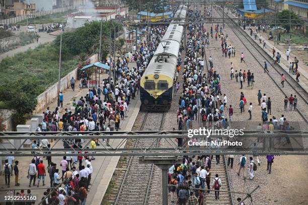 People wait to board an overcrowded train at a railway station in Ghaziabad, Uttar Pradesh, on the outskirts of New Delhi, India on April 28, 2023....