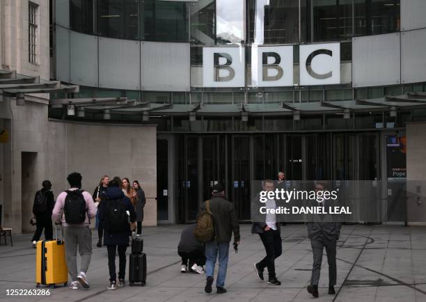 People use the front entrance of the headquarters of the British Broadcasting Corporation in London on April 28 on the day the BBC chairperson...