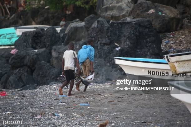 Fishermen are seen on the beach in Domoni, on the Anjouan island in the Comoros Archipelago on April 27, 2023. - Almost half of Comoros's 900,000...