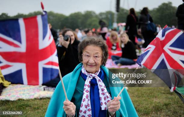 Royal fan holds British Union Jack flags as people gather to watch the wedding of Britain's Prince William and Kate Middleton on big screens in Hyde...
