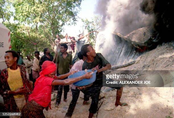 Somalis try to put out a fire 13 June that was started when U.S. AC-130 war planes bombed a depot of Somali warlord Mohamed Farrah Aidid. The United...