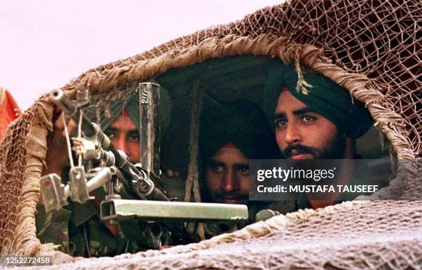 Battle-ready Indian soliders armed with a light machine gun head from Srinagar towards Kargil town 24 May 1999. Thousands of reinforments have been...