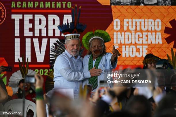 Brazilian President Luiz Inacio Lula da Silva and Indigenous leader of the Kayapo tribe Cacique Raoni Metuktire gesture during a visit to the Terra...