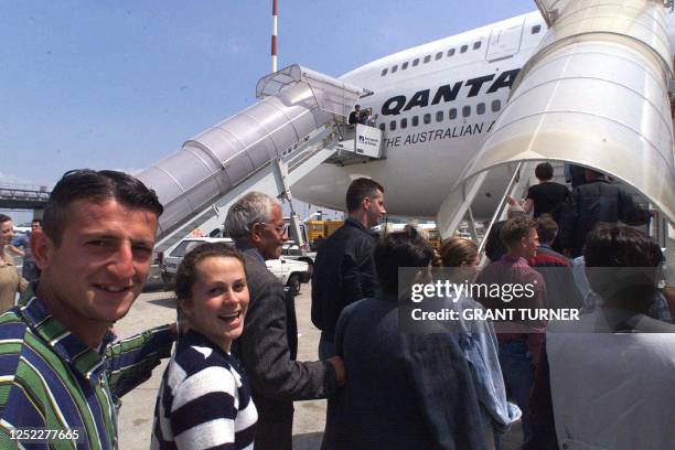 Refugees from Kosovo board a Qantas flight to Australia 06 May 1999 in Rome. More than 400 ethnic Albanians refugees flew off to Australia from...