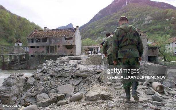 Yugoslav soldiers walk on Murino bridge alledgedly damaged by NATO air strikes, some 130 km from Podgorica, 02 May 1999. Five people were killed and...