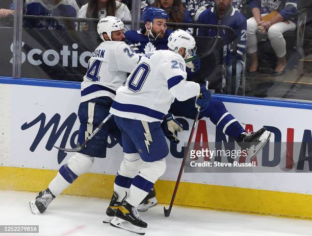 Toronto Maple Leafs center Ryan O'Reilly is checked by Tampa Bay Lightning defenseman Zach Bogosian and Tampa Bay Lightning left wing Nicholas Paul...