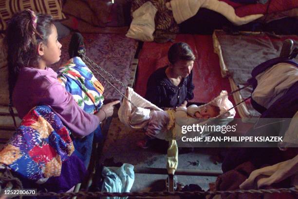 Woman cradles her child next to her daughter in a gipsy refugee camp set up by the Yugoslavian Red Cross in the northern Kosovar town of Leposavic 27...