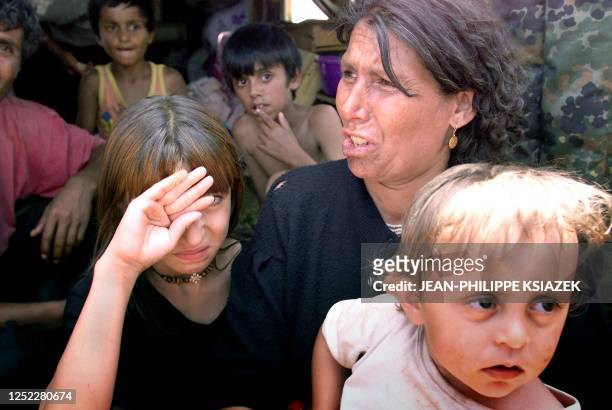 Rom woman and her daughter weep in a camp 04 July 1999 in Kosovo Polje, near Pristina where around 5,000 Kosovar gypsies have taken refuge after...