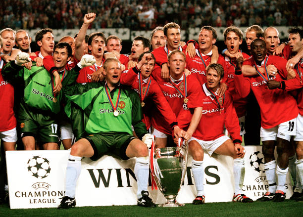 Manchester United players line up for a group photo as they celebrate with the trophy after winning the UEFA Champions League Final between...