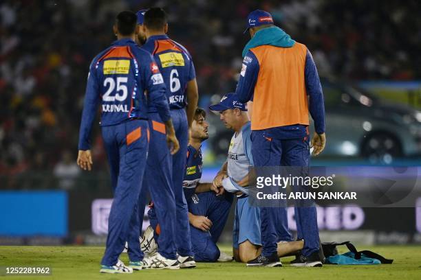 Lucknow Super Giants' Marcus Stoinis is being helped by a medic during the Indian Premier League Twenty20 cricket match between Punjab Kings and...