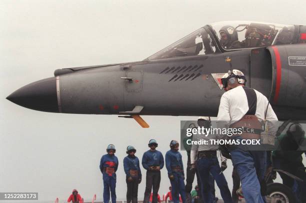 Les apponteurs assistent le pilote d'un Super-Etendard pour se positionner au décollage sur le porte-avions français, le 20 mai, en mer Adriatique,...
