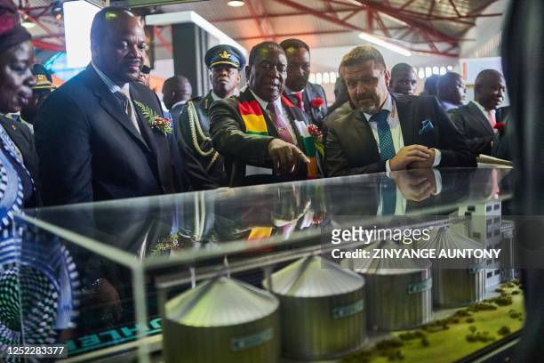 ESwatini's Mswati III and Zimbabwe President Emmerson Mnangagwa look on a displayed prototype of an energy plant currently under construction in...