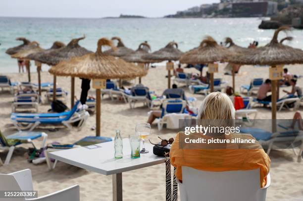 April 2023, Spain, Palma: People enjoying a warm day at Cala Major beach. Photo: Clara Margais/dpa