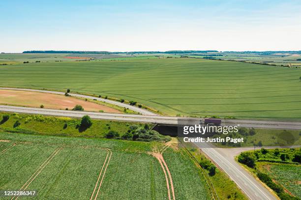 drone view of a uk motorway cutting through the countryside. - lorry uk photos et images de collection