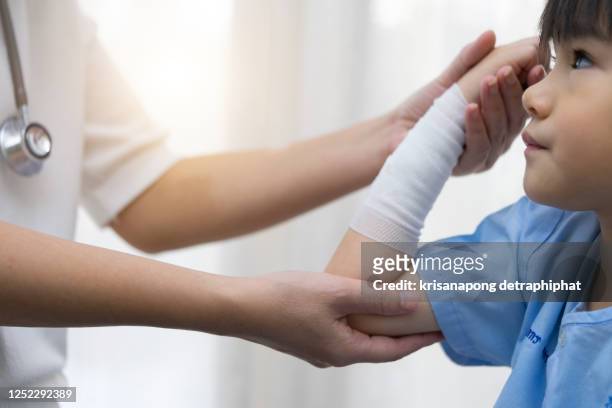 doctor treating patients - boy broken arm stock pictures, royalty-free photos & images
