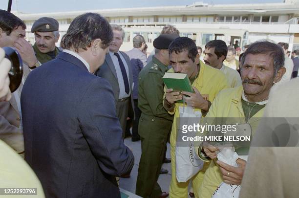 Two Iraqi POW , holding and kissing the Holy Koran 24 November 1988, thank God for their return home to Baghdad, during Iraq-Iran war. The Iraq-Iran...