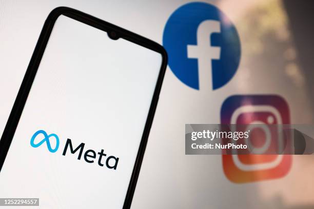 In this photo illustration a Meta logo seen displayed on a smartphone screen with Facebook and Instagram logos on a MacBook screen in Athens, Greece...