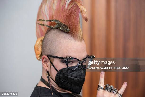 Attendee wears a frog and skull in her har, satanic rings on her hand while giving the hail satan salute at Satan Con in Boston, Massachusetts, on...
