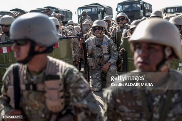 Peruvian soldiers stand on arrival for surveillance and patrol operations, in Tacna, in the Peru-Chile border on April 28, 2023. - Peru mobilized 200...