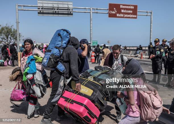 Migrants of various nationalities are escorted by Peruvian police officers to a migration office in Tacna, in the Peru-Chile border on April 28,...