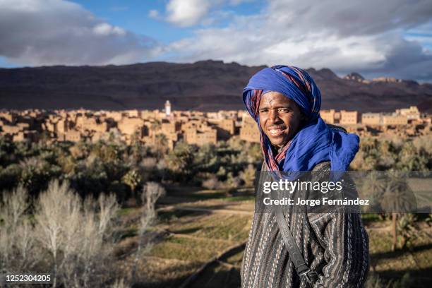 Portrait of a young man dressed in the typical clothes of Berber nomads next to a viewpoint over the Tinghir oasis.