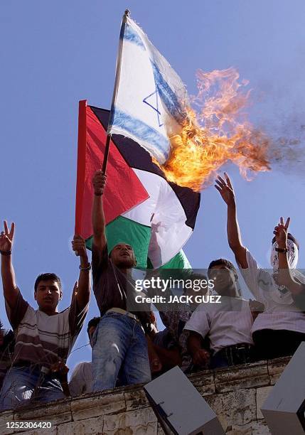 Palestinian protesters burn an Israeli flag during a demonstration against the Sharm el-Sheikh summit in Khan Yunes in the Gaza Strip 16 October...