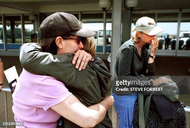 British VSO workers, English language teachers, Joan Macleod from the Isle of Lewis and Tracey Hopps from Newcastle, hug 21 May 2000 as British and...