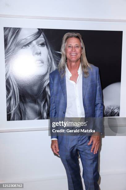 Australian photographer Russell James stands in front of the picture he took of model Toni Garrn at his Vernissage at Camera Work Gallery on April...