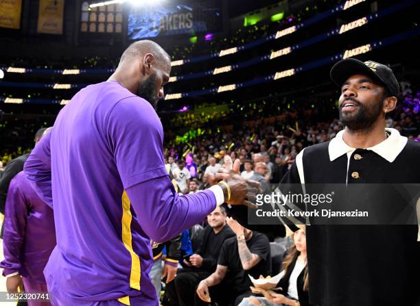 Kyrie Irving of the Dallas Mavericks greets LeBron James of the Los Angeles Lakers as he attends a basketball game between Los Angeles Lakers and...