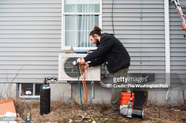 Matt Johnson an HVAC technician with ReVision Energy, a New England company specializing in solar energy and electric heat pump installations, works...