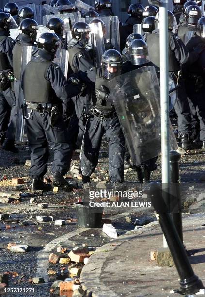 An injured police officer is helped away through the debris from the front line as Nationalists riots in the Belfast neighbourhood of Ardoyne 12 July...