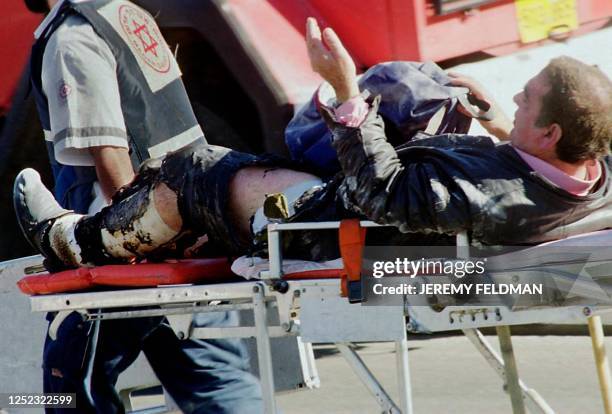 Wounded Israeli is rushed to an ambulance after a bomb attack on a public transport bus in Tel Aviv 28 December 2000. The attack, in which 13 people...