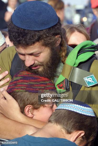 Relatives of two settler children found murdered in a West Bank cave 09 May 2001 embrace each other in grief during the teenagers' funeral at the...