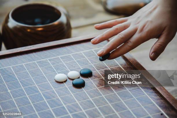 female hand playing the game of go - spelregels stockfoto's en -beelden