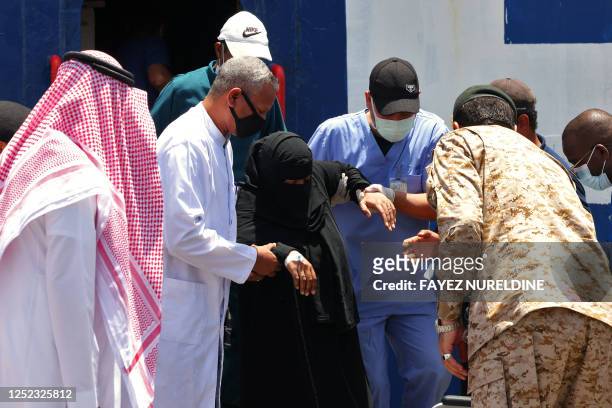 Saudi officials and medics assist people stepping off a ferry which transported some 1900 evacuees across the Red Sea from port Sudan to the Saudi...