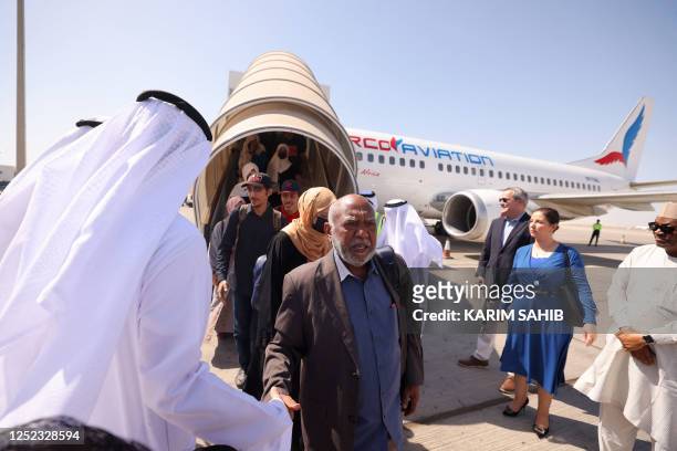 Evacuees from Sudan are welcomed by Emirati officials on April 29, 2023 at the tarmac of an airport in Abu Dhabi. - Warplanes on bombing raids drew...