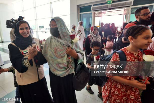 People fleeing conflict in Sudan are welcomed by Emirati officials at an airport in Abu Dhabi after an evacuation flight, on April 29, 2023. -...