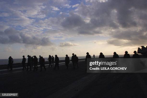 Flight crew walk on the flight deck of the USS Enterprise aircraft carrier to launch fighter planes heading for missions to Afghanistan 14 October...