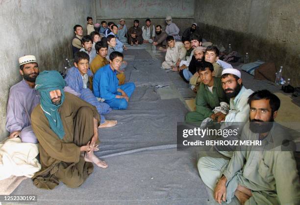 Afghan refugees sit in a cell as they are detained in the Iranian city of Zahedan after illegally crossing into Iran 10 October 2001. Iran, already...