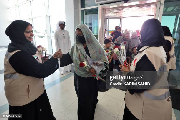 People fleeing conflict in Sudan are welcomed by Emirati officials at an airport in Abu Dhabi after an evacuation flight, on April 29, 2023. -...