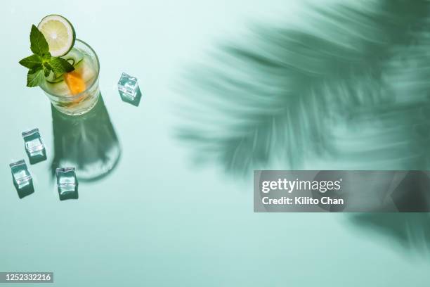 summer cocktail drinks with fresh ingredients and palm tree shadow - fruits table top stockfoto's en -beelden