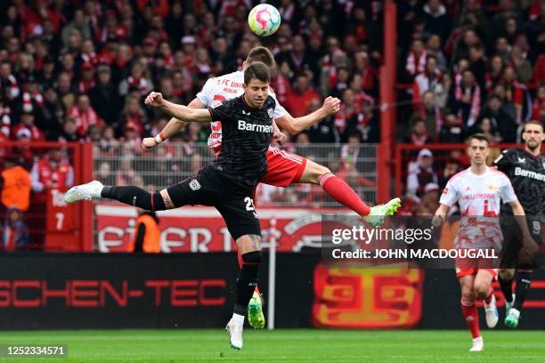 Leverkusen's Czech forward Adam Hlozek and Union Berlin's German defender Robin Knoche both jump to head the ball during the German first division...