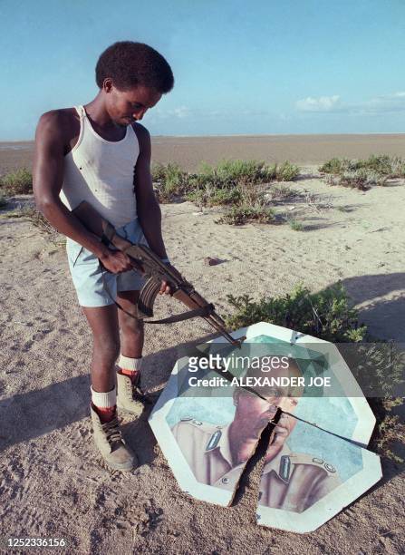 Rebel militiaman belonging to the Somali National Movement, fighting the regime of dictator Mohamed Siad Barre, points his gun towards the broken...