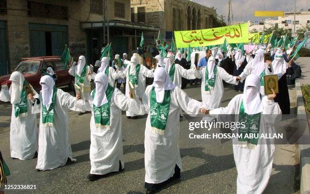 Supporters of the radical Islamic group Hamas holds up copies of the Koran during a protest in the West Bank town of Hebron 25 October 2001 in...