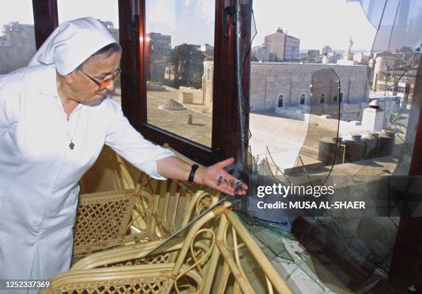 Franciscan nun shows 23 October 2001 the shattered glass of a window at the Franciscan hospital for children which was hit by Israeli shooting in the...