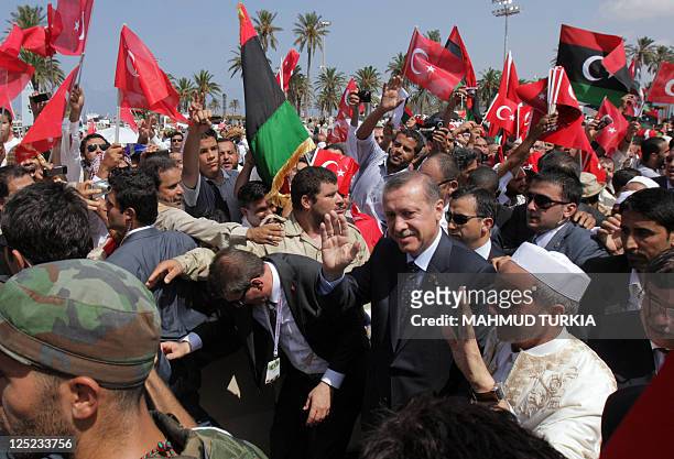 Turkish Prime Minister Recep Tayyip Erdogan and Libya's interim leader Mustafa Abdel Jalil wave as they attend Friday prayers in Tripoli on September...